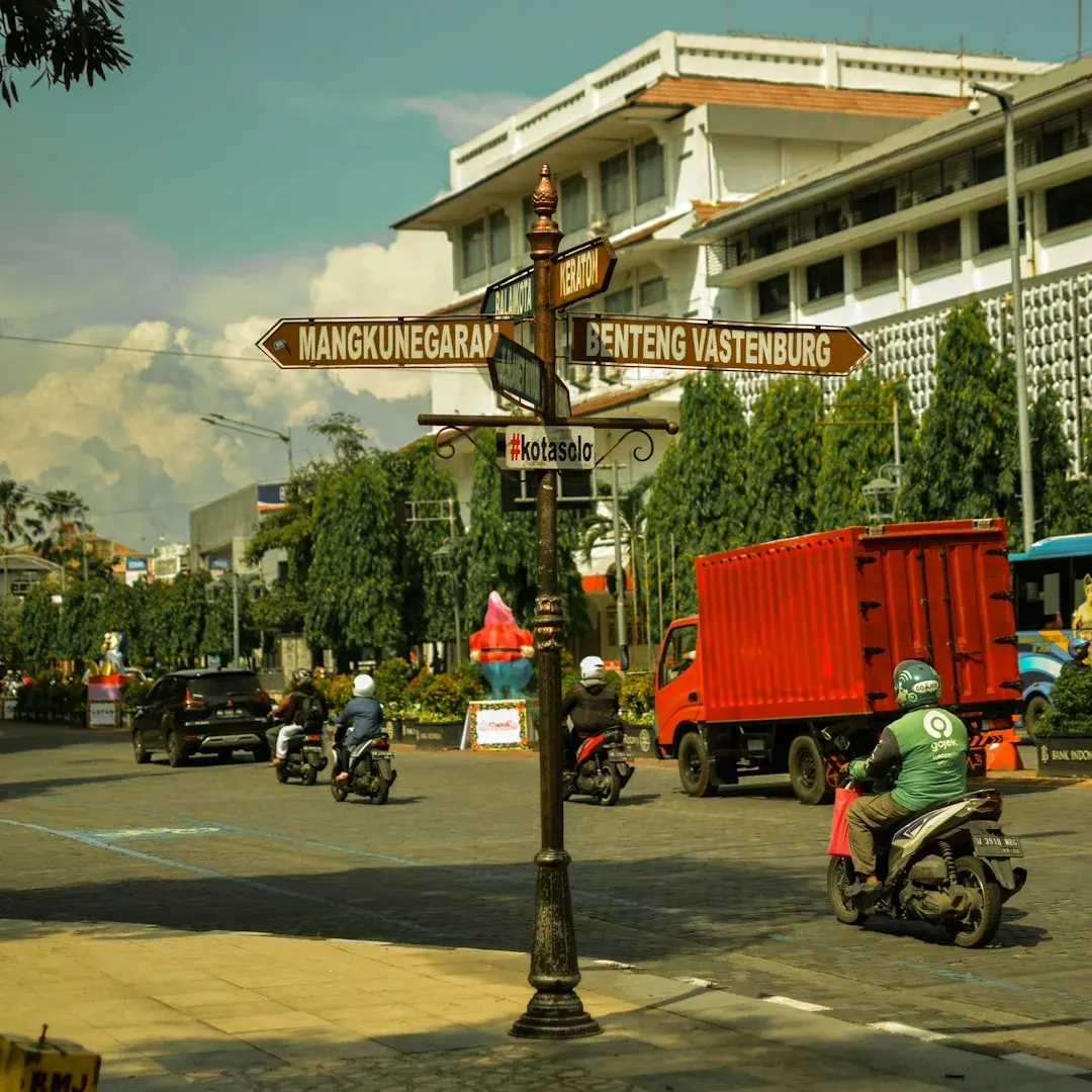 A wide illustration of Jakarta at golden hour: the National Monument (Monas) in the foreground, the city skyline stretching behind it, and a clear amber sky above.