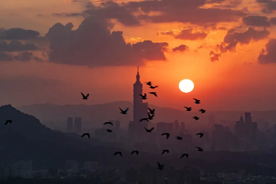 A warm wide illustration of Taipei at golden hour, Taipei 101 rising above the city, green Xiangshan (Elephant Mountain) ridgeline in the foreground, soft amber light over the basin.