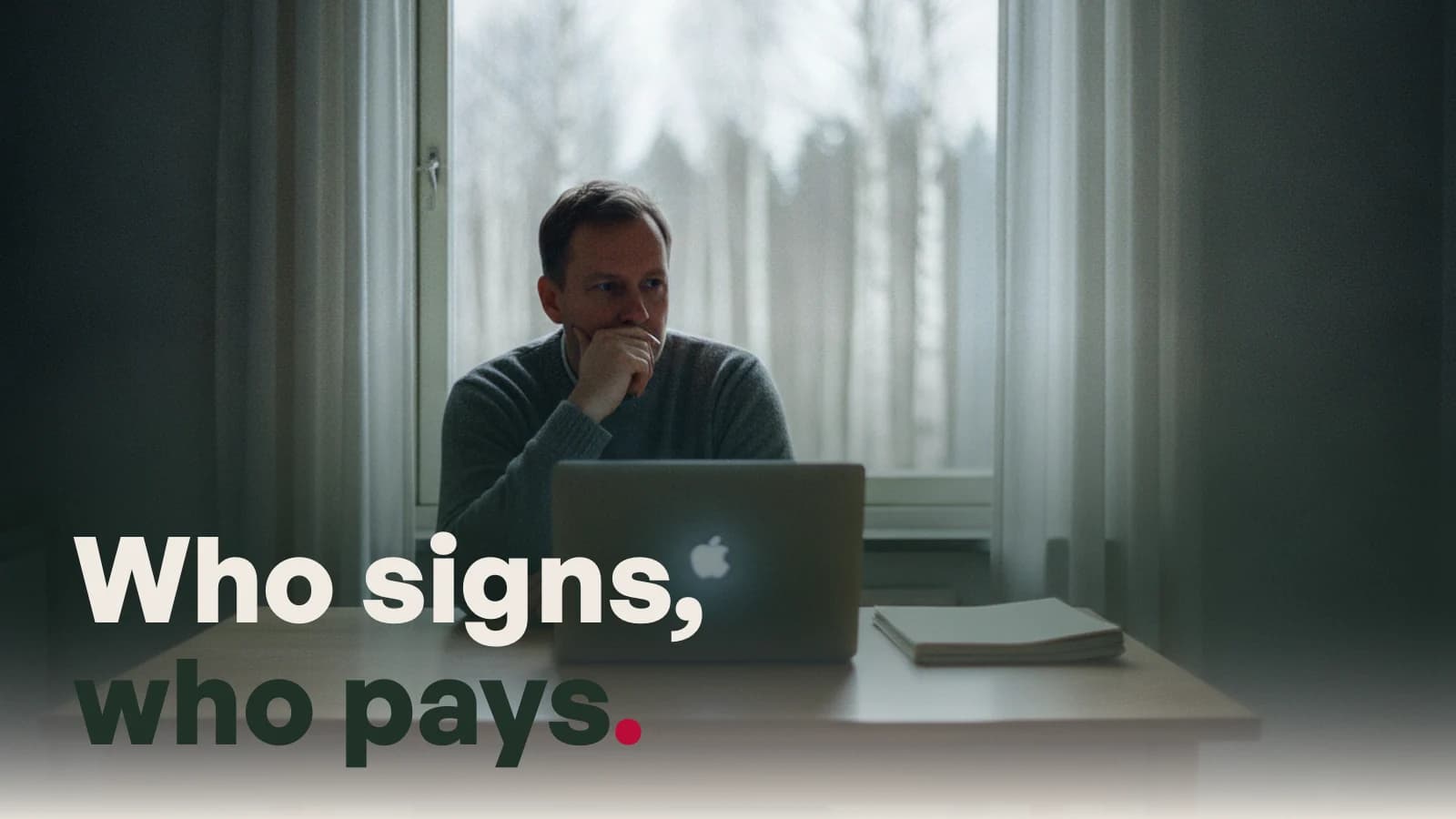 A man at a kitchen table in a Nordic apartment with a laptop and a printed contract, with the line Who signs, who pays.
