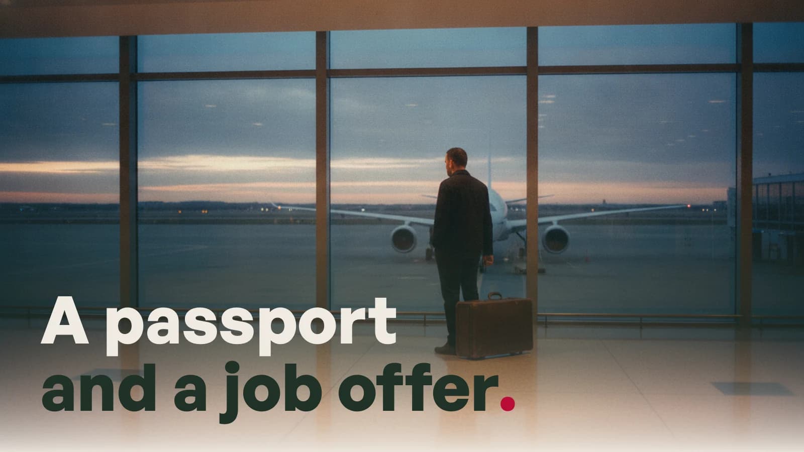 A man waiting with a suitcase in an airport departure hall at dusk, with the line A passport and a job offer.