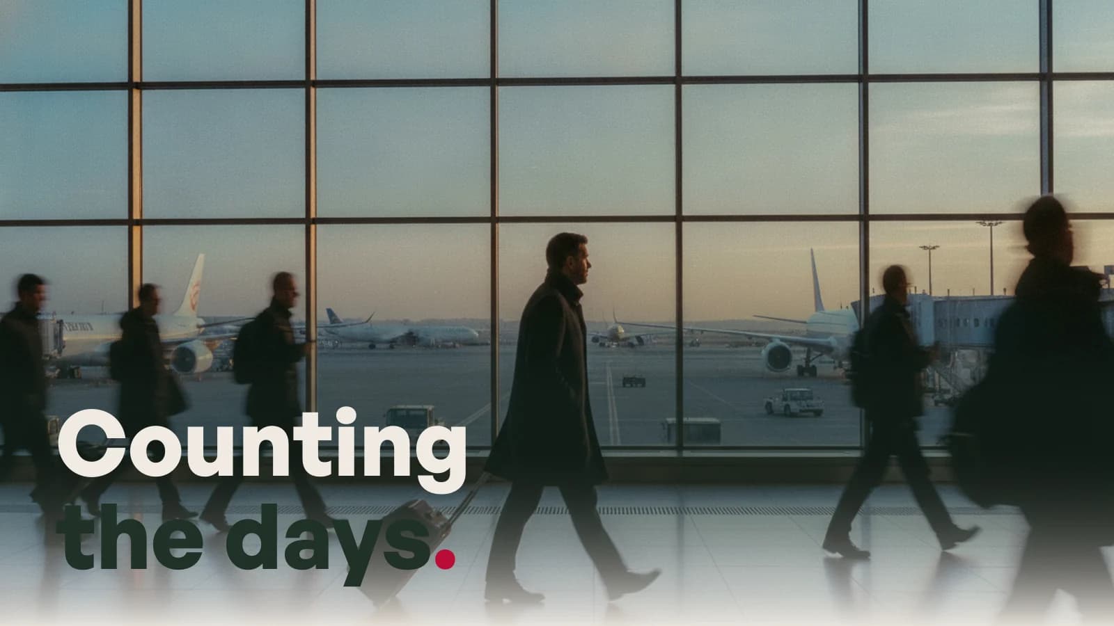 A business traveller walking through an airport terminal at dawn, with the line Counting the days.