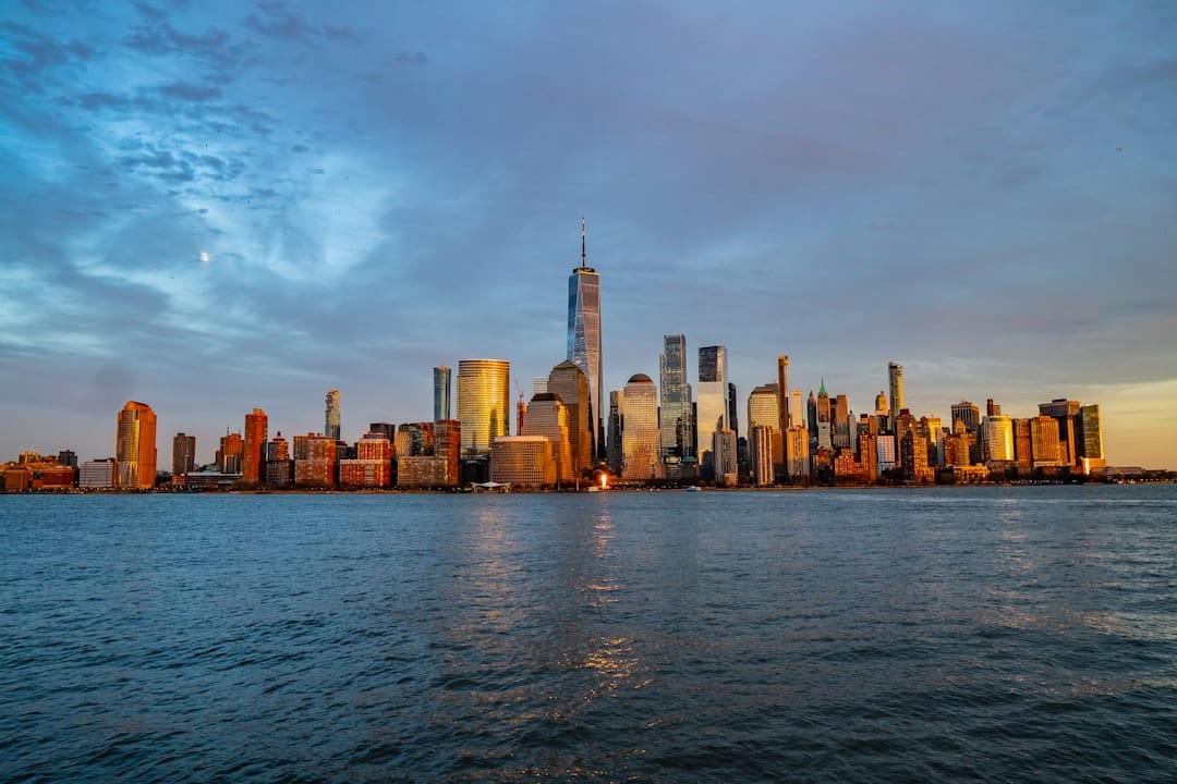 New Jersey skyline viewed from the water at dusk, city towers reflecting in the harbour with a warm amber sky