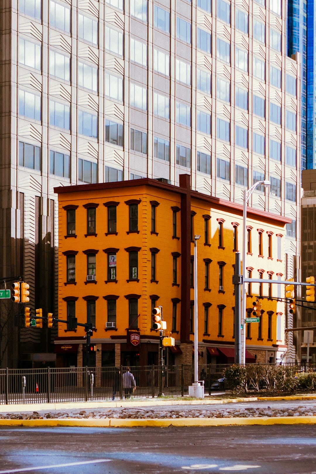 A busy city street in New Jersey, commuters moving through morning light between office towers