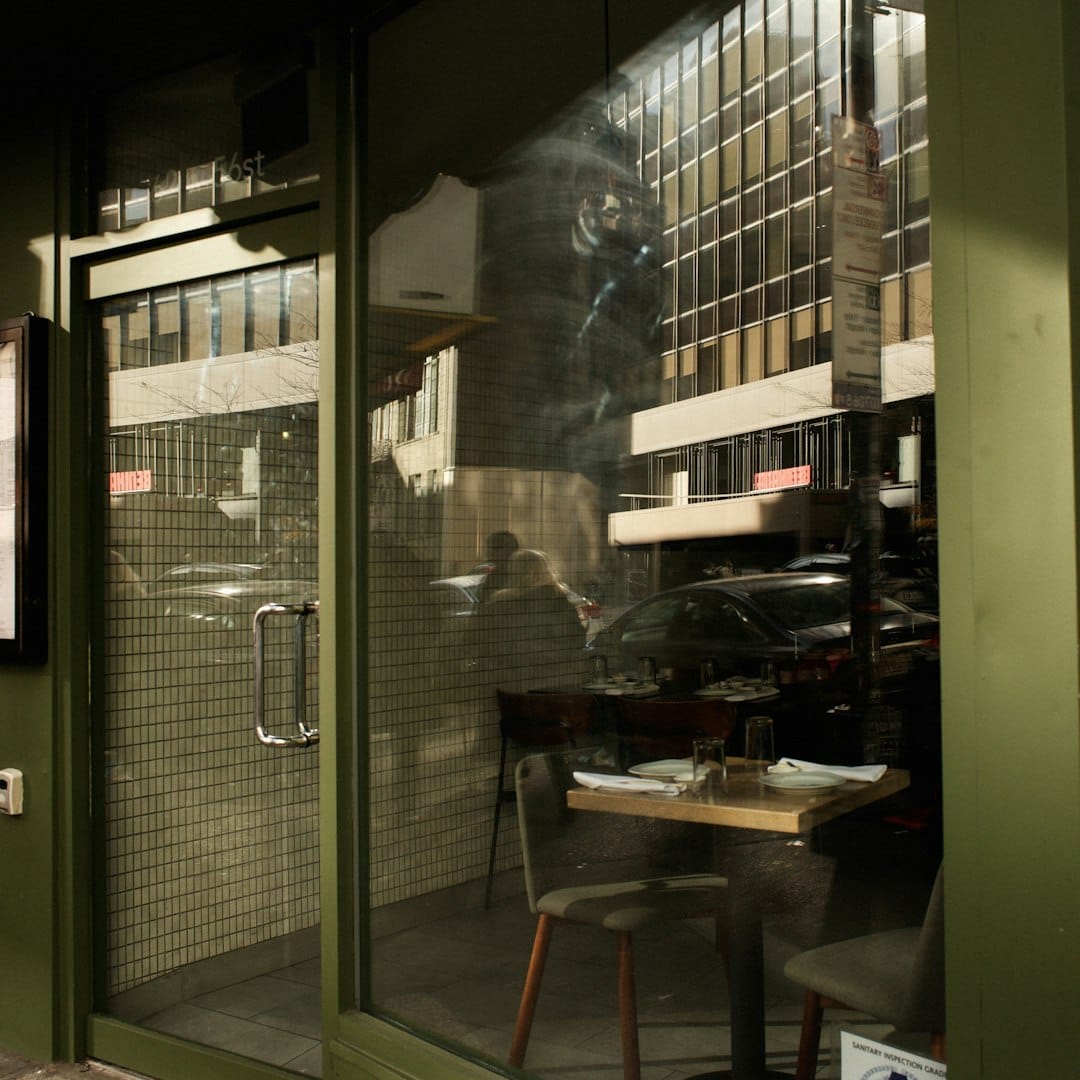New York City diner interior at night, warm lights reflected in the glass door