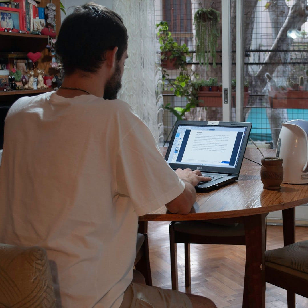 Professional at a cafe table reviewing documents, morning light through a window