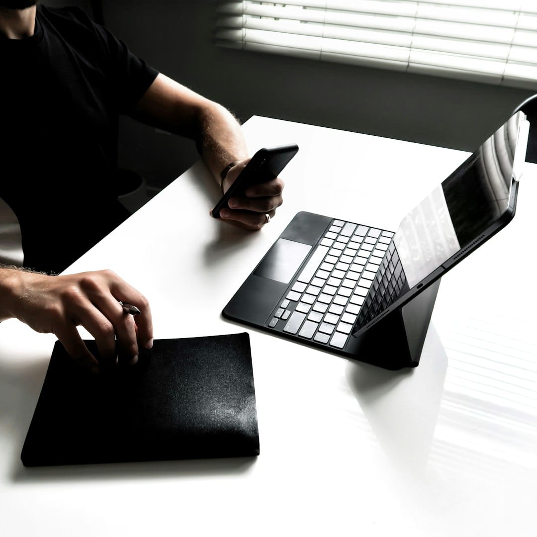 A professional working on a laptop at a modern workspace setup, focused and productive