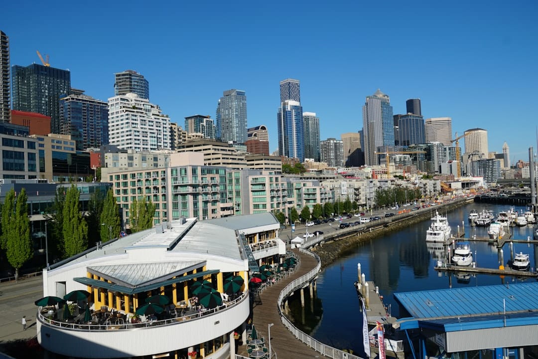 A panoramic view of Seattle city from a high vantage point, with downtown buildings and waterways below under an overcast sky.