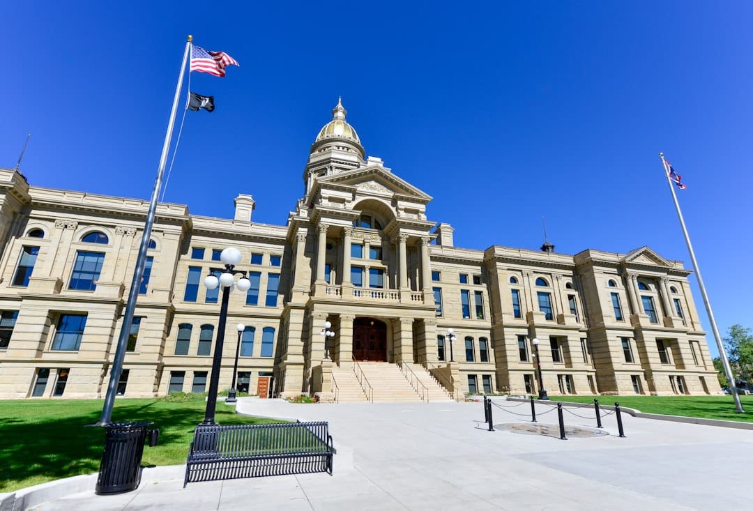 A government building with a flag against a clear sky in Cheyenne, Wyoming, representing the state's regulatory environment for contractors.