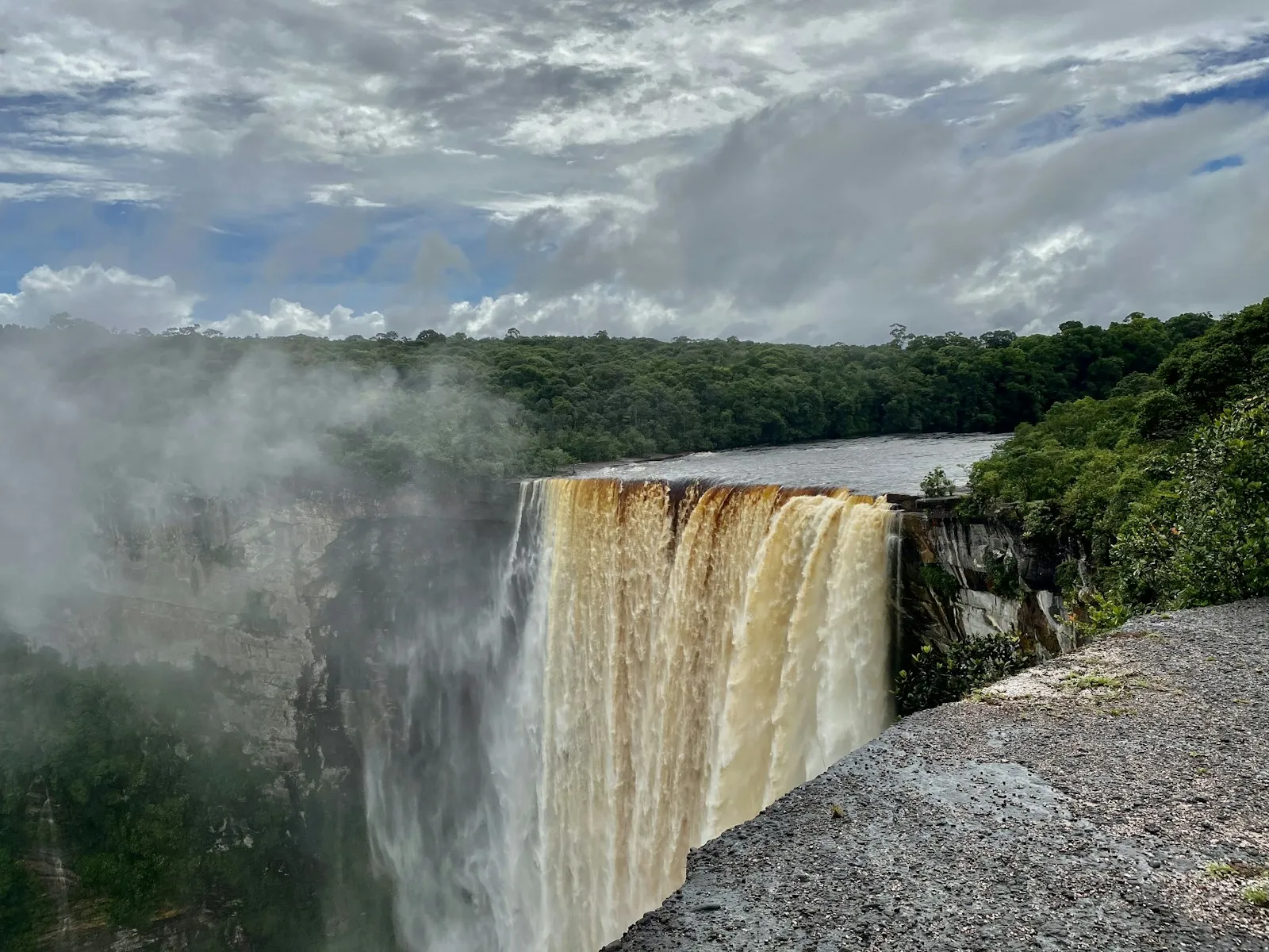 Kaieteur Falls pouring over a sandstone cliff into a forested gorge under cloud in Guyana.