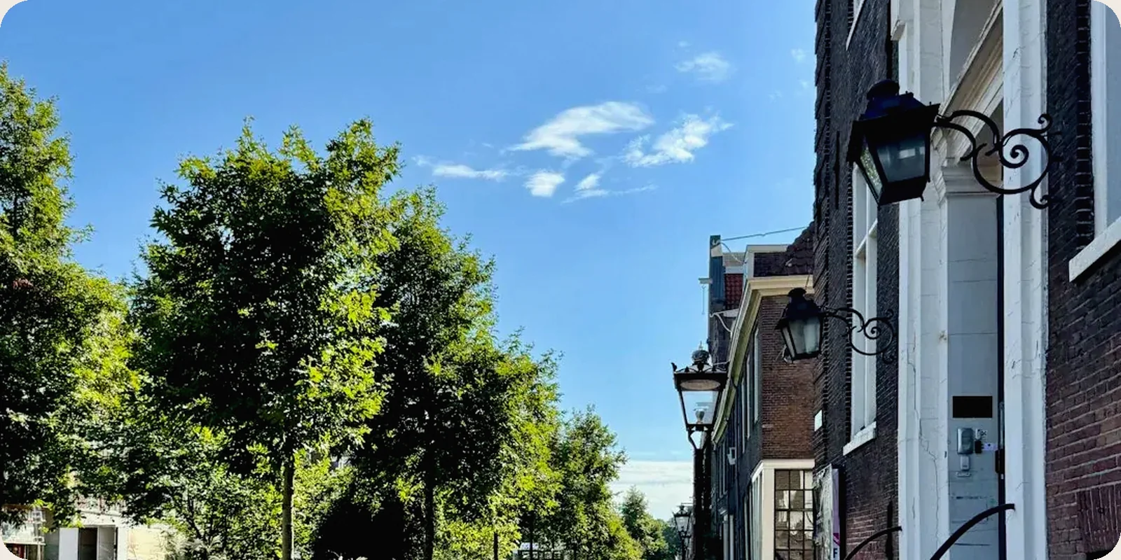 A Dutch canal with houseboats and gabled buildings behind.
