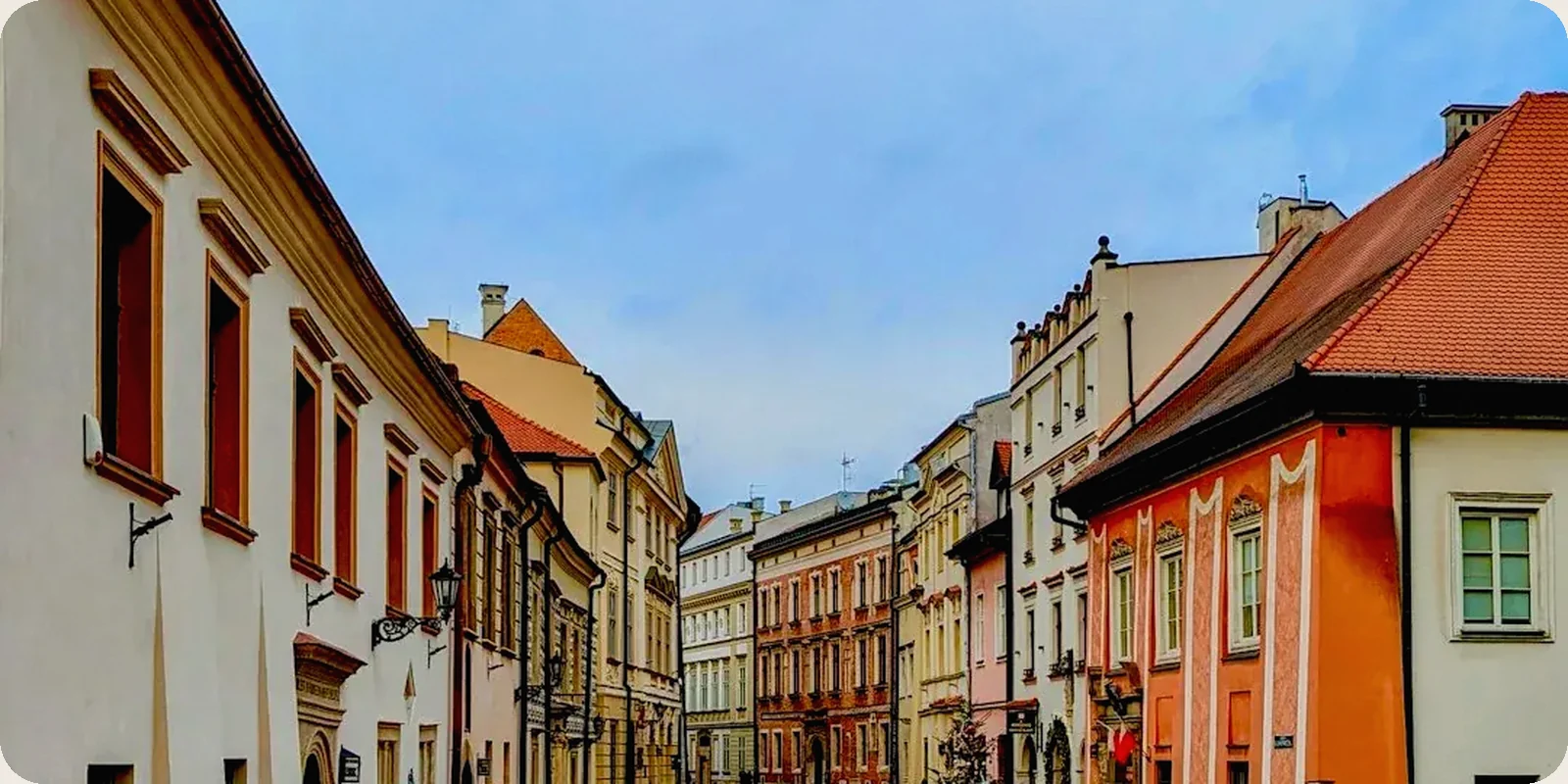 A Polish city square with historic buildings in afternoon light.