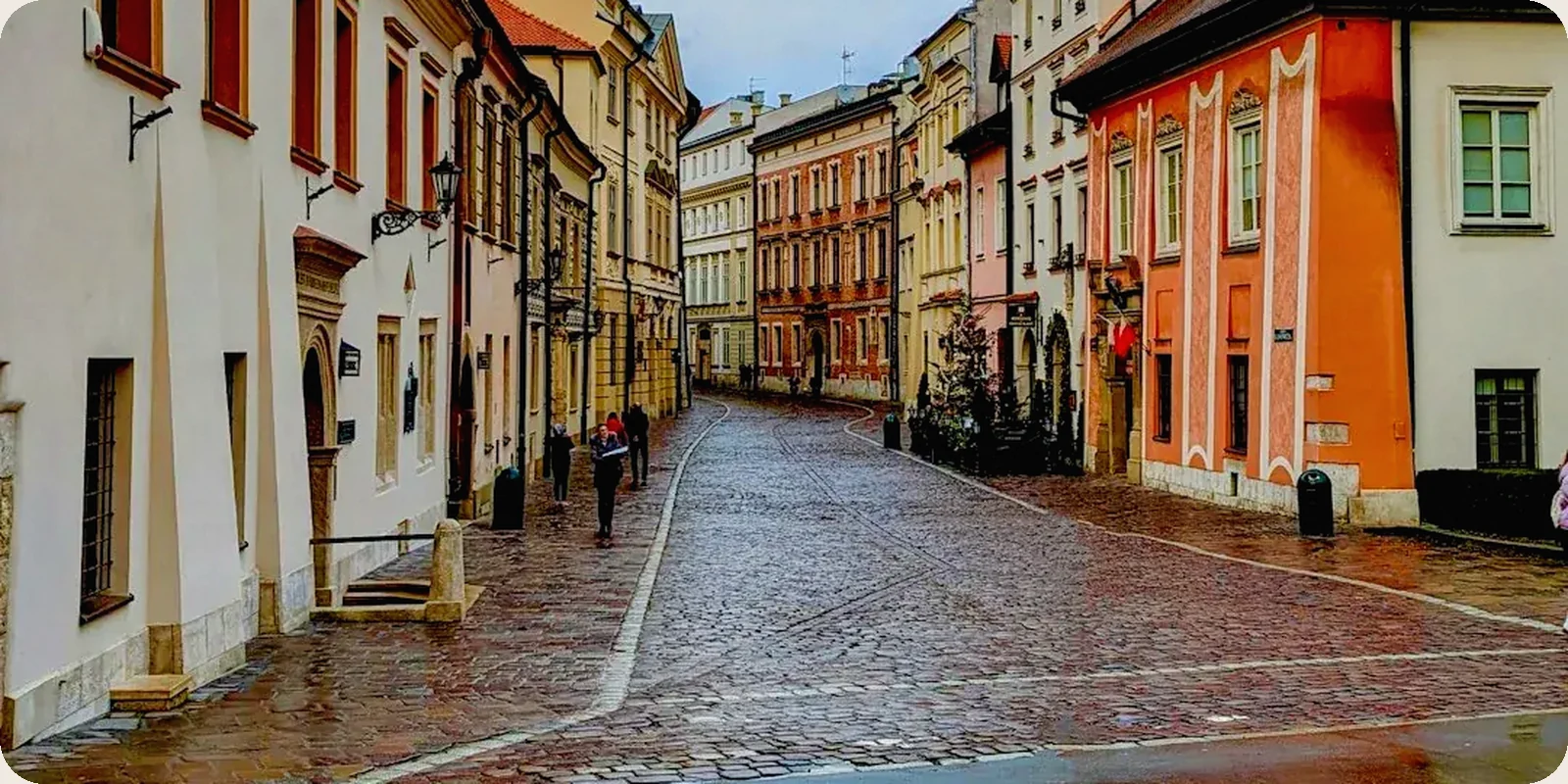A Polish city square with historic buildings in afternoon light.