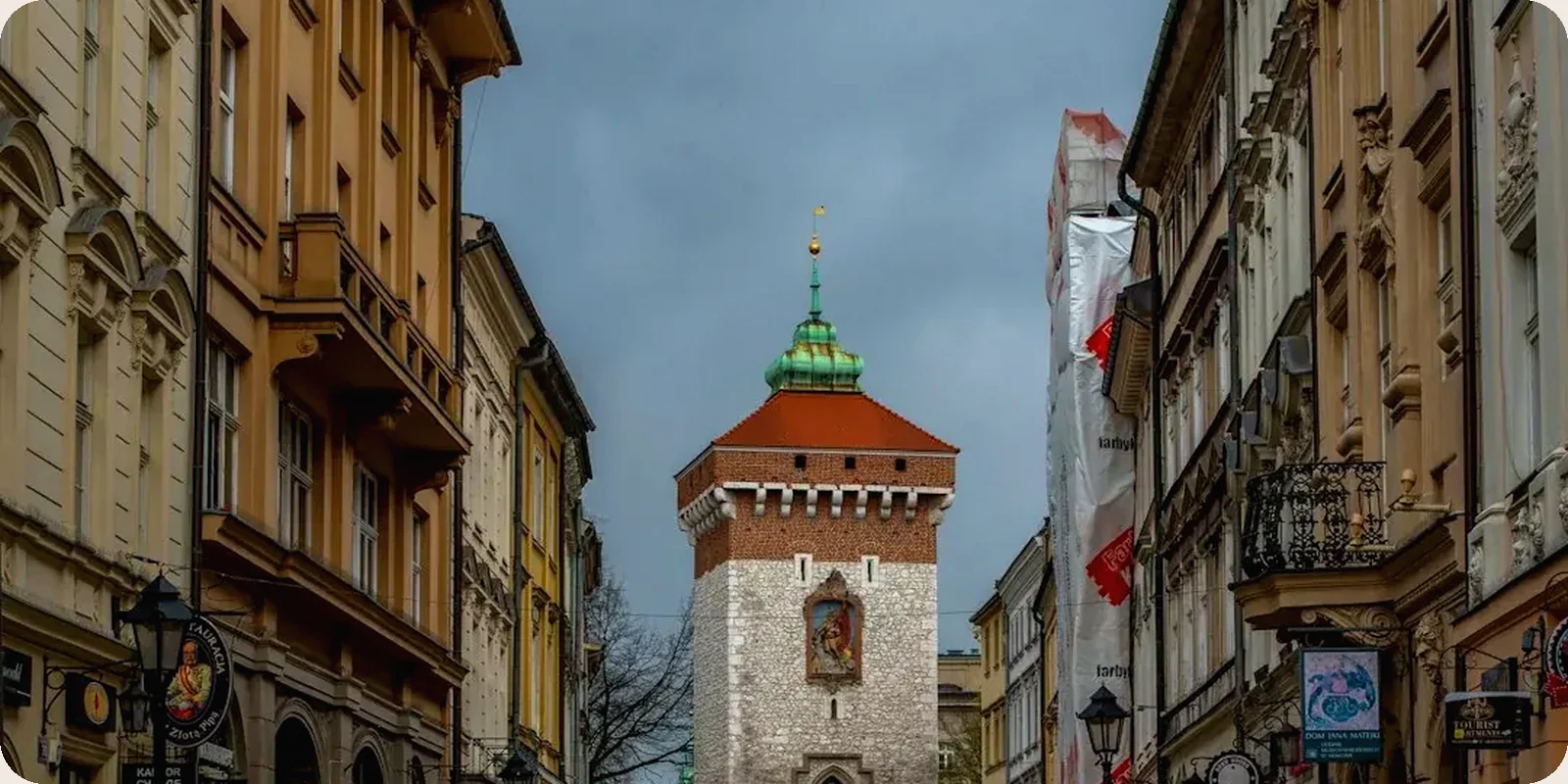 A Polish city square with people walking past historic buildings.