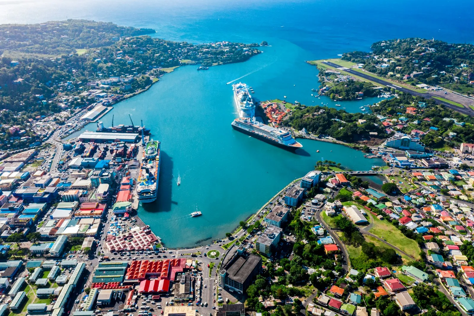 An aerial view of Castries harbour, with a cruise ship at the quay and the city around the bay in Saint Lucia.