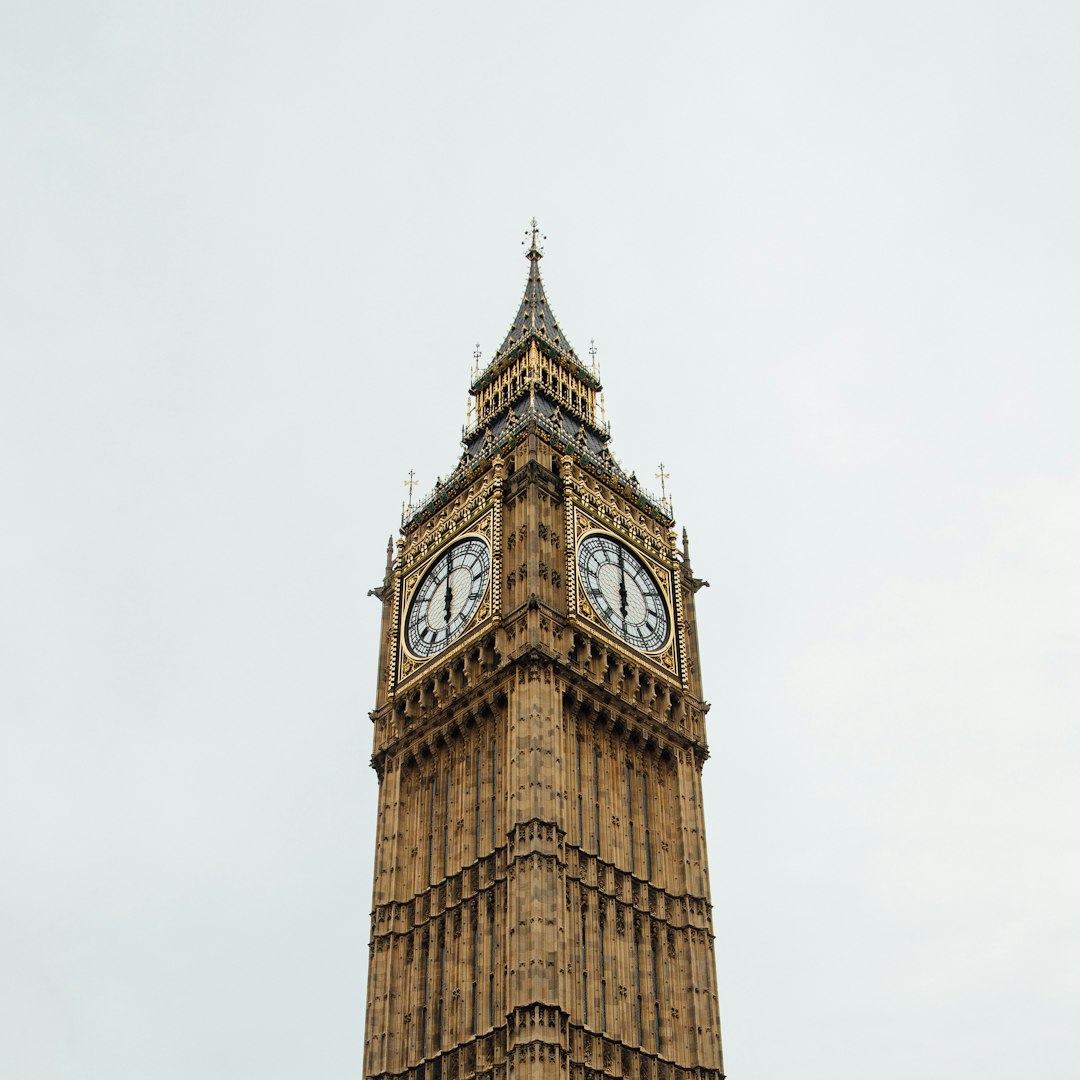 Big Ben, the Elizabeth Tower at the Palace of Westminster, against a pale sky.