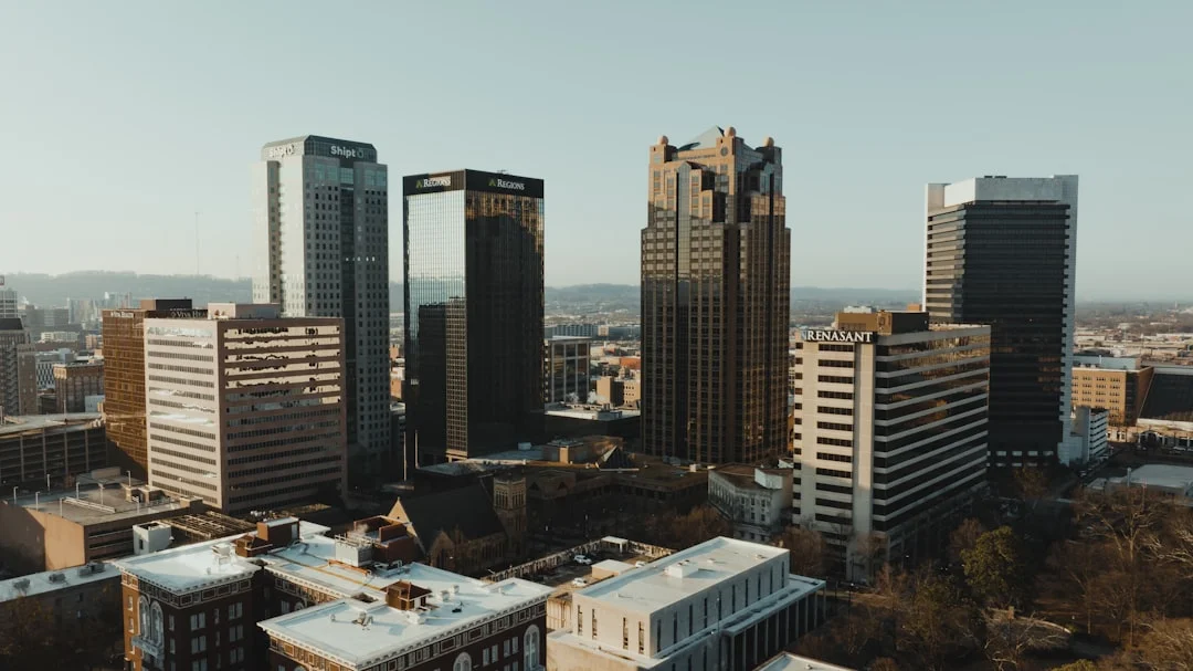 Aerial view of downtown Birmingham, Alabama at midday, modern office towers rising above the surrounding streets.