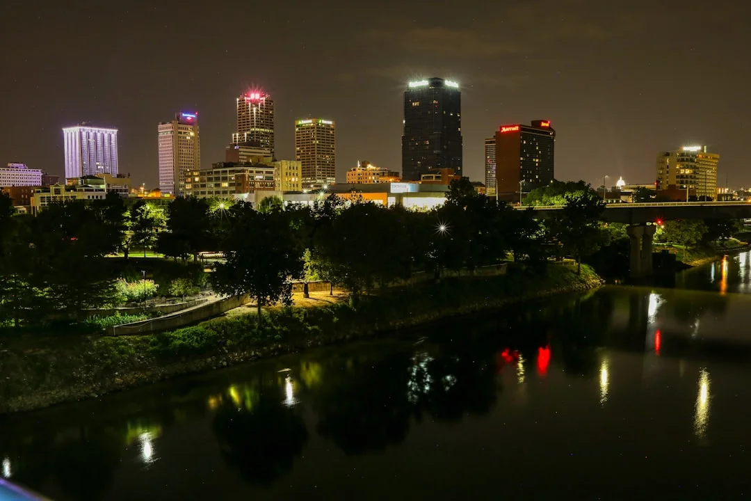 Little Rock, Arkansas downtown skyline at night with the Arkansas River in the foreground.