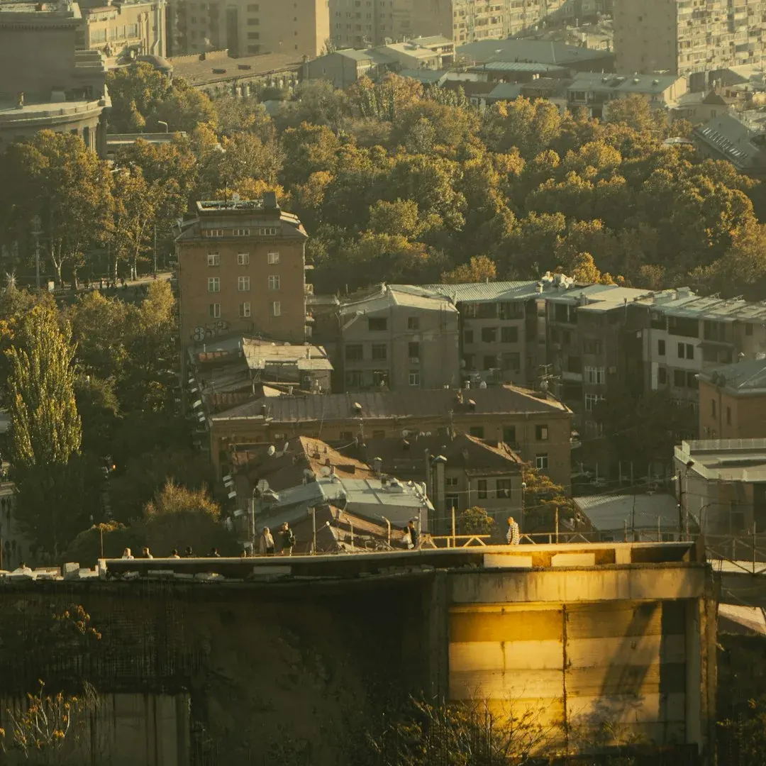 A quiet cafe terrace on a stone-paved street in Yerevan's Kentron district in soft afternoon light.