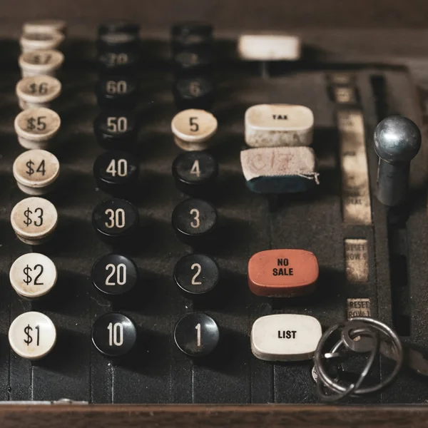 A vintage black mechanical adding machine.