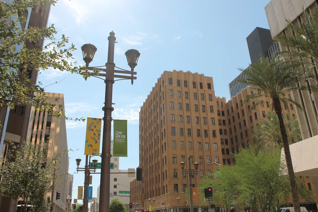 High-rise buildings rising above a street-level stop sign in downtown Phoenix, Arizona, late afternoon.