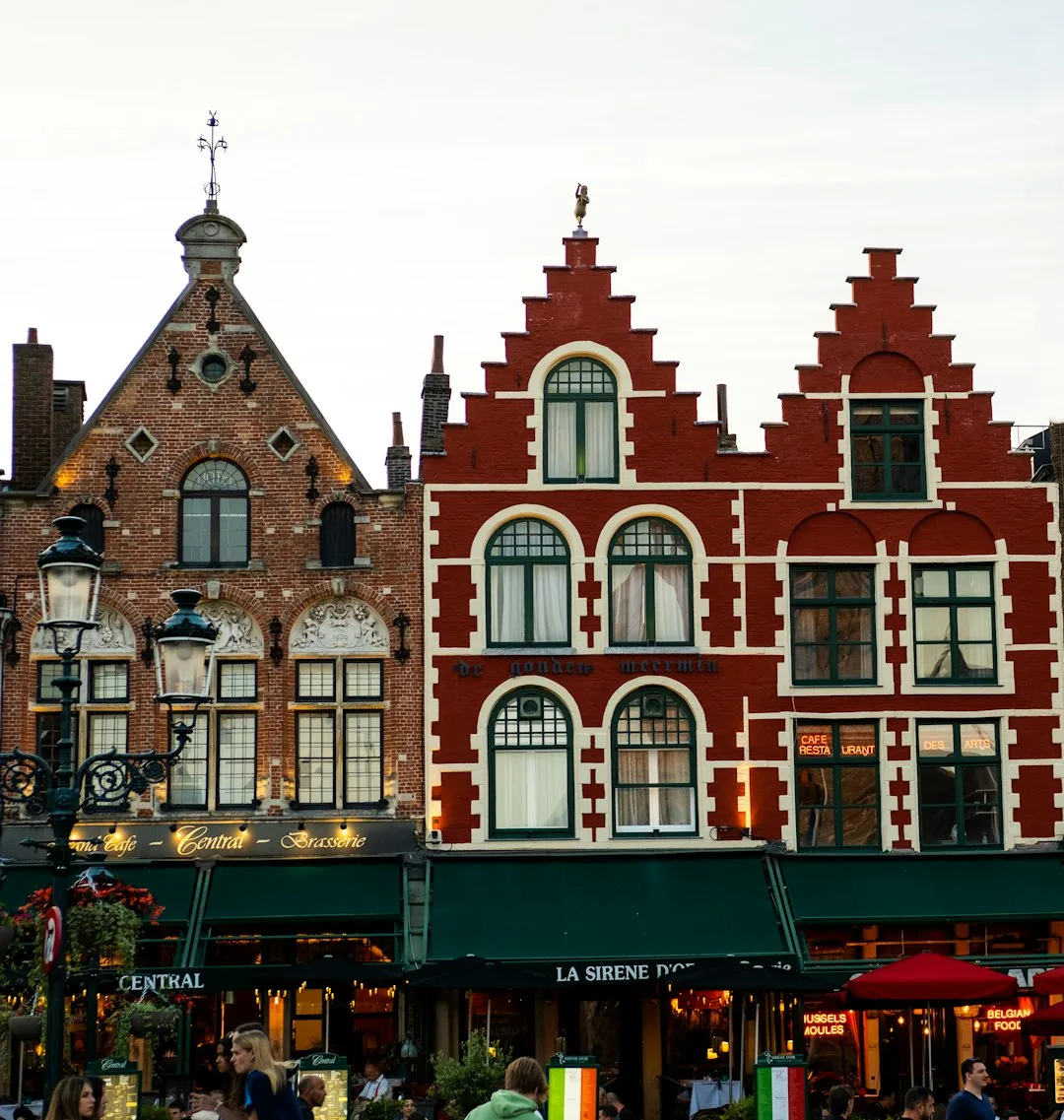 A view across the Grand Place in Brussels with the ornate guild houses lit in morning light.