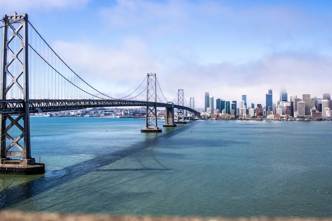 The San Francisco-Oakland Bay Bridge stretching across the bay during daytime, with city skyline behind.