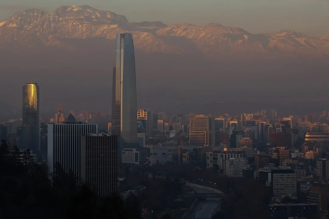 Santiago skyline at golden hour with the Andes mountains behind the Costanera Center tower.