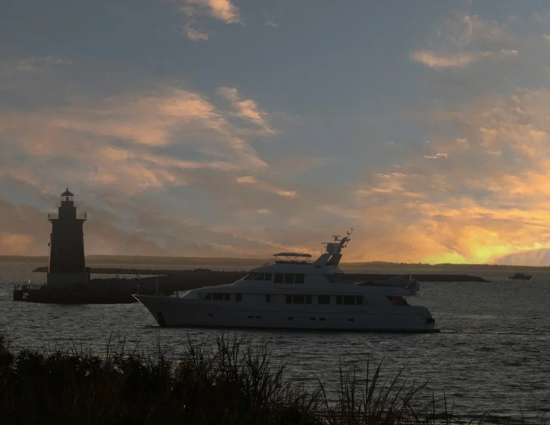 Coastal Delaware lighthouse and harbour, with a small boat in calm water near a working pier under a clear winter sky.