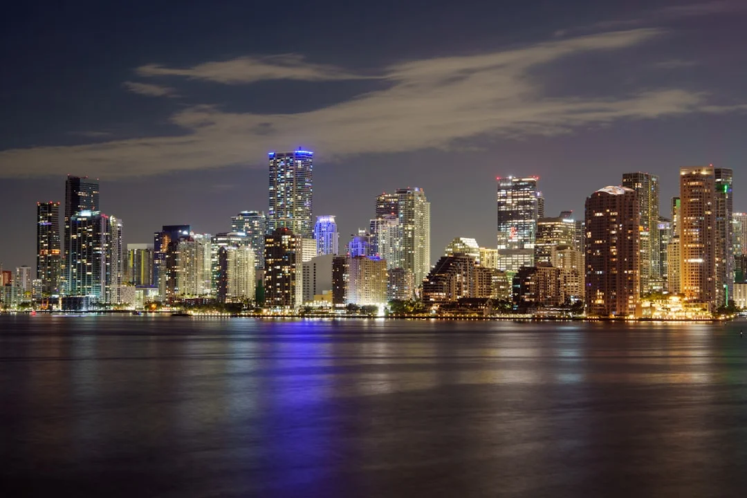 Illuminated skyscrapers and high-rise buildings line the Miami, Florida downtown skyline at dusk.