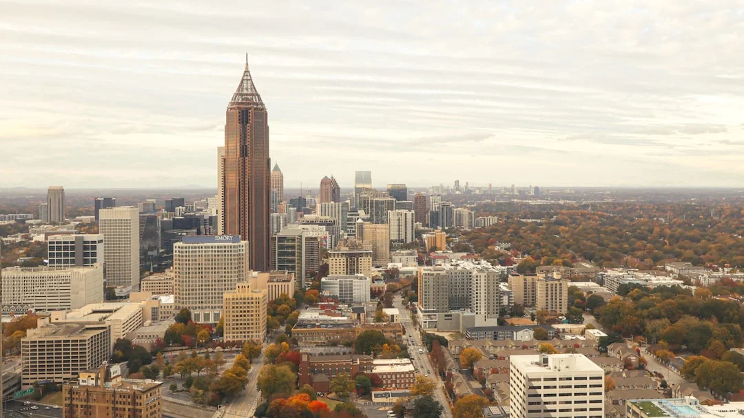 Atlanta, Georgia downtown skyline with the Westin Peachtree Plaza cylinder, Bank of America Plaza spire, and a sprawling business district stretching to the horizon.