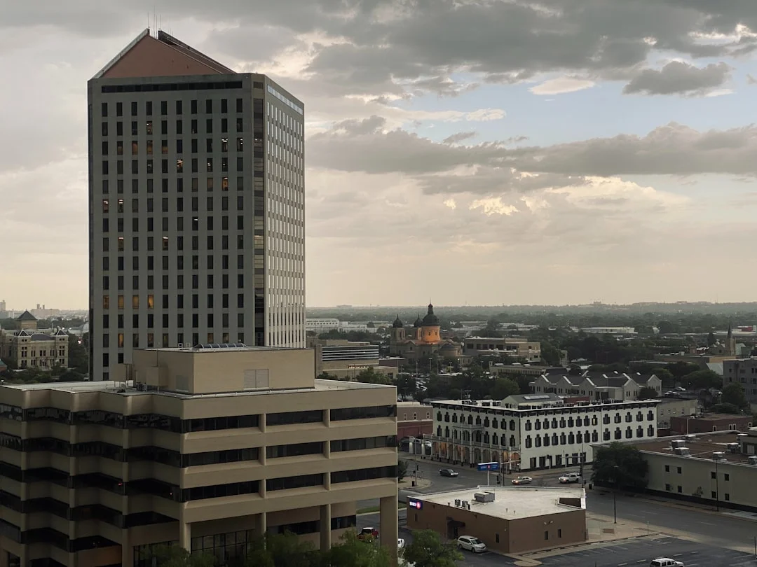 Wichita, Kansas downtown skyline with the Arkansas River and modern buildings at dusk.