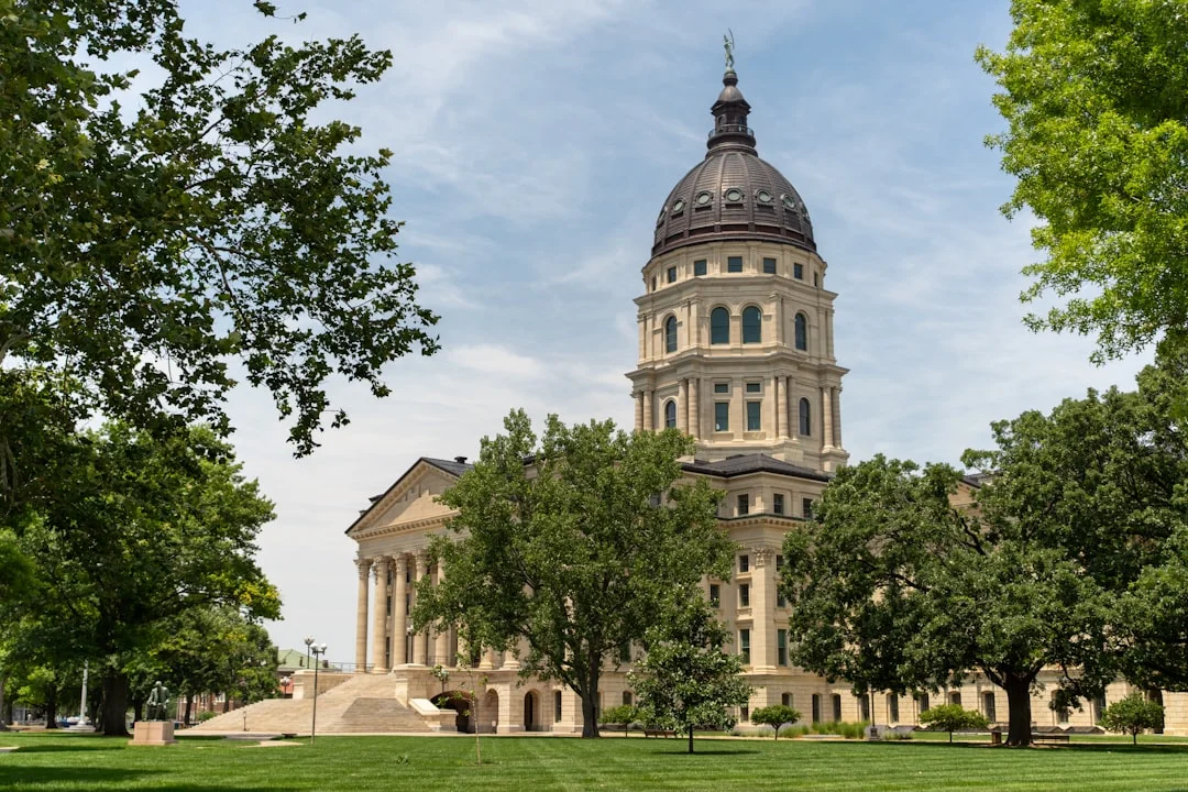 Topeka Kansas State Capitol building, its dome rising against a clear sky, the seat of Kansas state government and legislature.