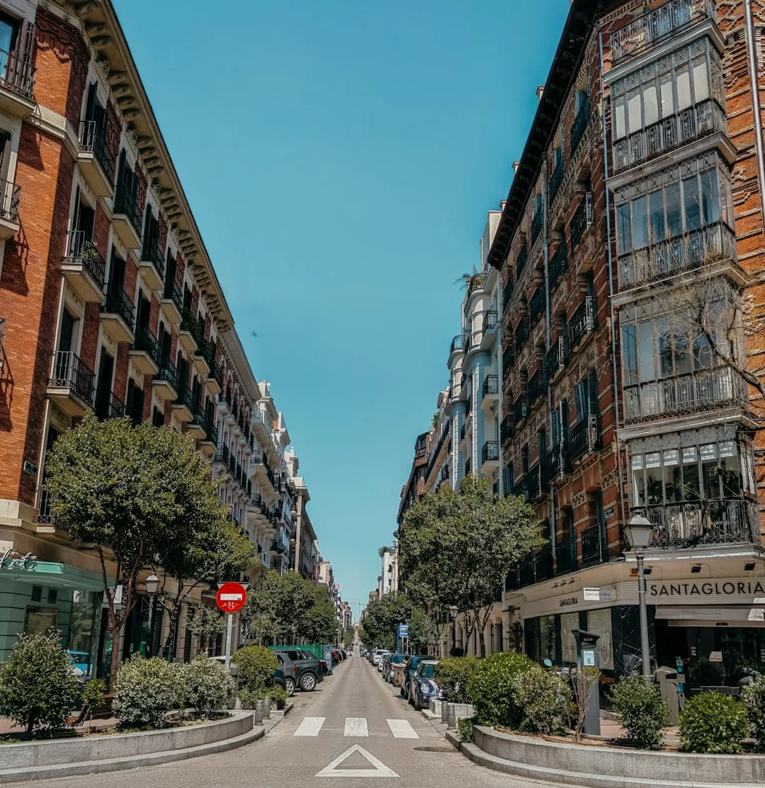 A sunlit co-working terrace in the Eixample district of Barcelona, with a freelancer at a laptop and a coffee in the morning.